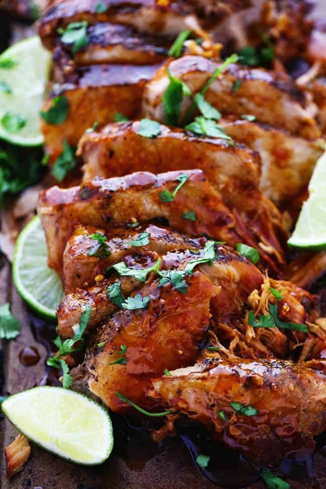 Delicious and tender pork cooked in the slow cooker with a honey, lime, soy, garlic, and ginger infused marinade. We loved it so much we had it twice in one week! Slow cooker honey lime ginger pork with fresh-cut limes on the side.