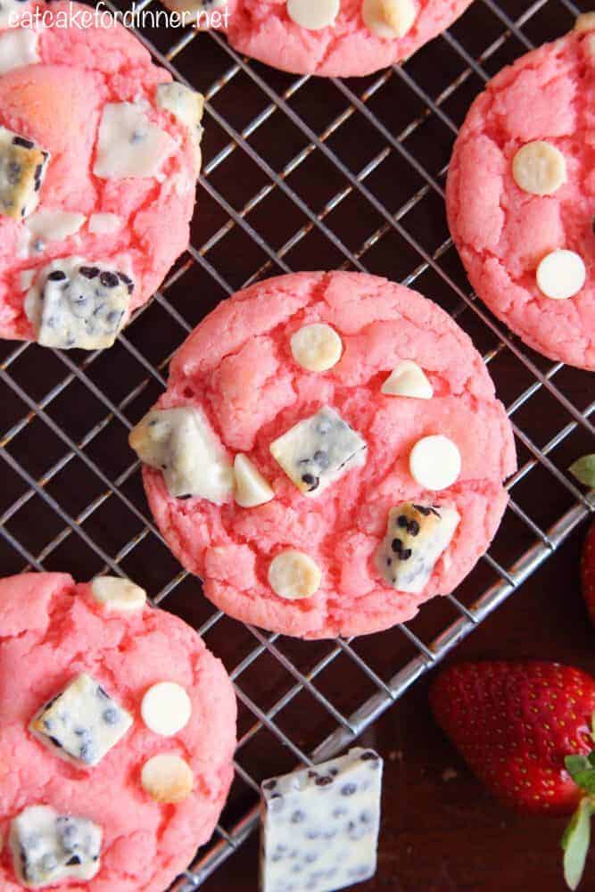 Easy and delicious cookies that are made with a cake mix and pudding mix with delicious cookies and cream pieces hidden inside! They are a fun pink color with a crisp edge and chewy center! Strawberry Cookies 'n Cream Cookies on a cooling sheet.