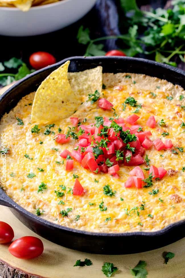 Queso Verde Corn Dip is creamy cheesy, bubbly, packed with flavor and one of the easiest, tastiest appetizers you will ever make! Queso verde corn dip in a large skillet with chips dipped into it.