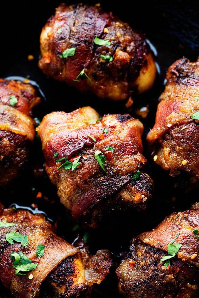 Tender and Juicy Chicken that is wrapped in bacon and coated in a blend of spices. It bakes in brown sugar which caramelizes when it cooks. You are going to love the sweet and spicy flavor! Overhead photo of sweet and spicy bacon wrapped chicken in a skillet.