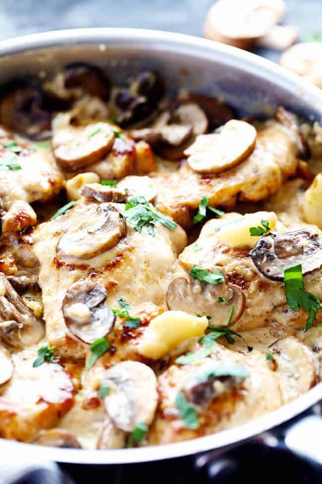 Tender and juicy chicken in the most amazing creamy and delicious garlic mushroom sauce! This makes one incredible 30 minute meal! Creamy garlic mushroom chicken in a frying pan.