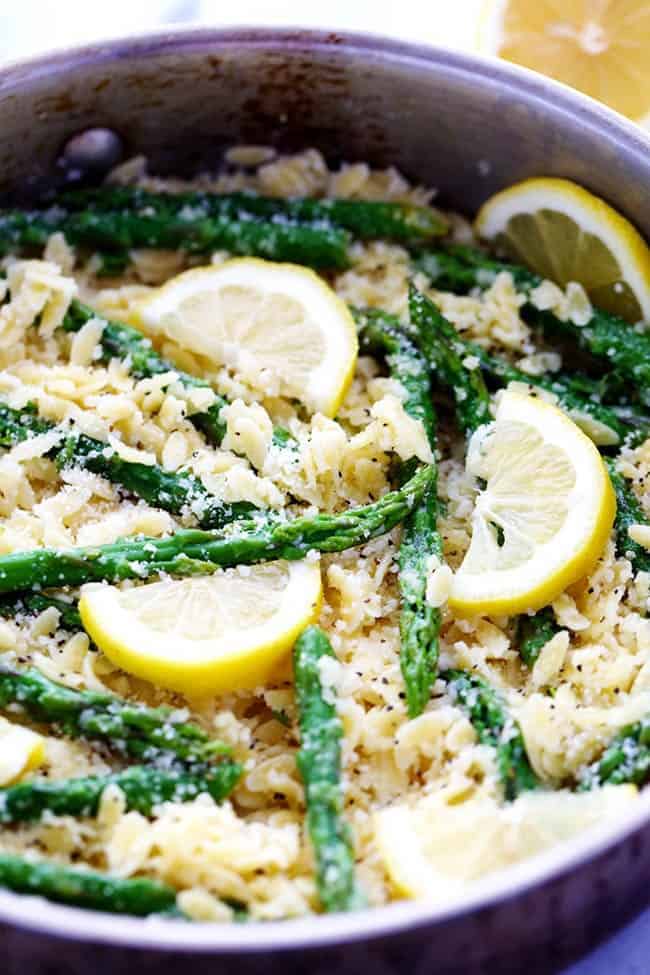 A buttery lemon parmesan garlic sauce coats orzo pasta and gives it such amazing flavor! It gets tossed with asparagus and makes one delicious meal! Lemon Parmesan Garlic Orzo with Asparagus in a large metal pot.
