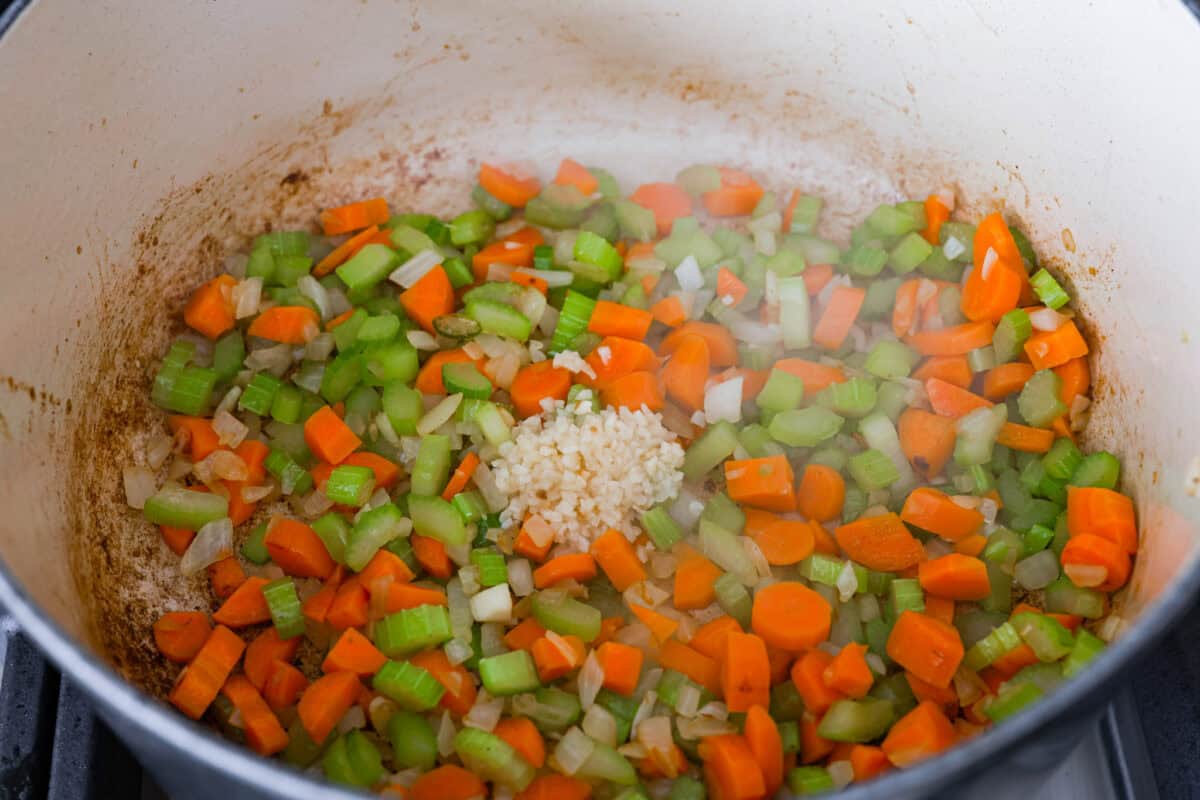This hearty Vegetable Beef Soup is comforting and flavor-packed! It's loaded with beef, potatoes, and veggies that simmer to tender perfection. A classic and easy one-pot soup for a chilly night. Third photo of the veggies cooked and the garlic added.