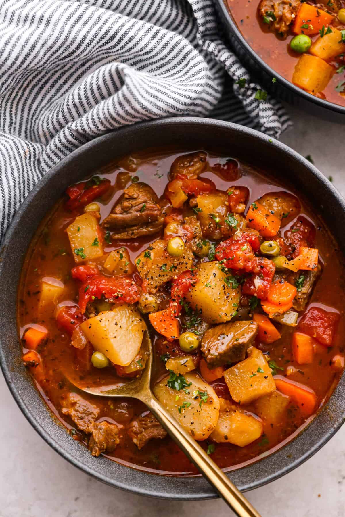 This hearty Vegetable Beef Soup is comforting and flavor-packed! It's loaded with beef, potatoes, and veggies that simmer to tender perfection. A classic and easy one-pot soup for a chilly night. Top view of a bowl of soup with a spoon.