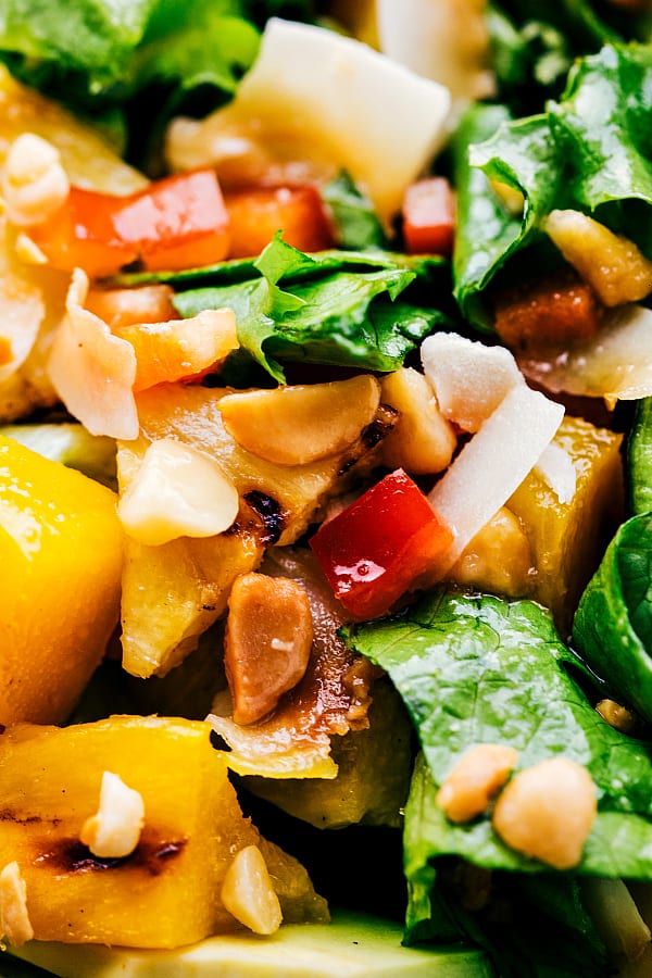 Delicious grilled mango and pineapple tossed in a mouthwatering salad! You will want to make this all summer long! Up close photo of grilled mango and pineapple salad.
