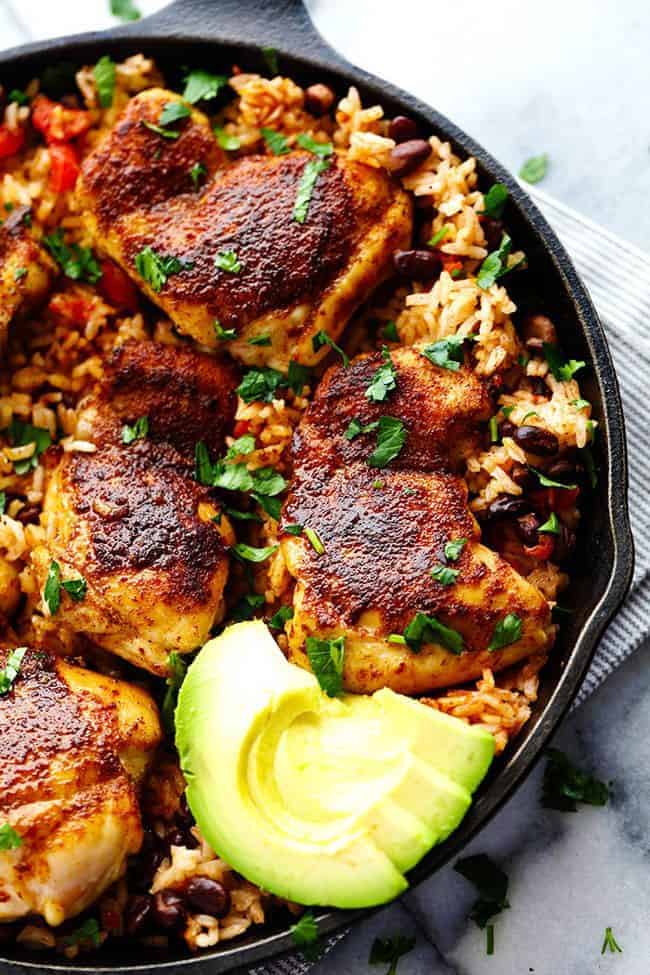 An amazing one pan meal with tender and juicy cajun blackened chicken over delicious southwest rice! This meal became an instant favorite at our house! One Pan Southwest Blackened Cajun Chicken with Rice in a skillet with fresh cut avocado on the side.