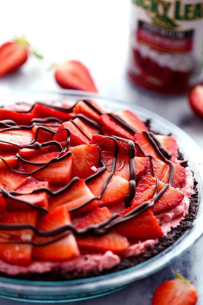 An amazing no bake pie with a chocolate crust filled with a creamy strawberry filling. It gets topped with fresh strawberries and drizzled in chocolate and will be a huge hit wherever it goes!ย No Bake Chocolate Strawberries and Cream Pie in a clear pie dish.