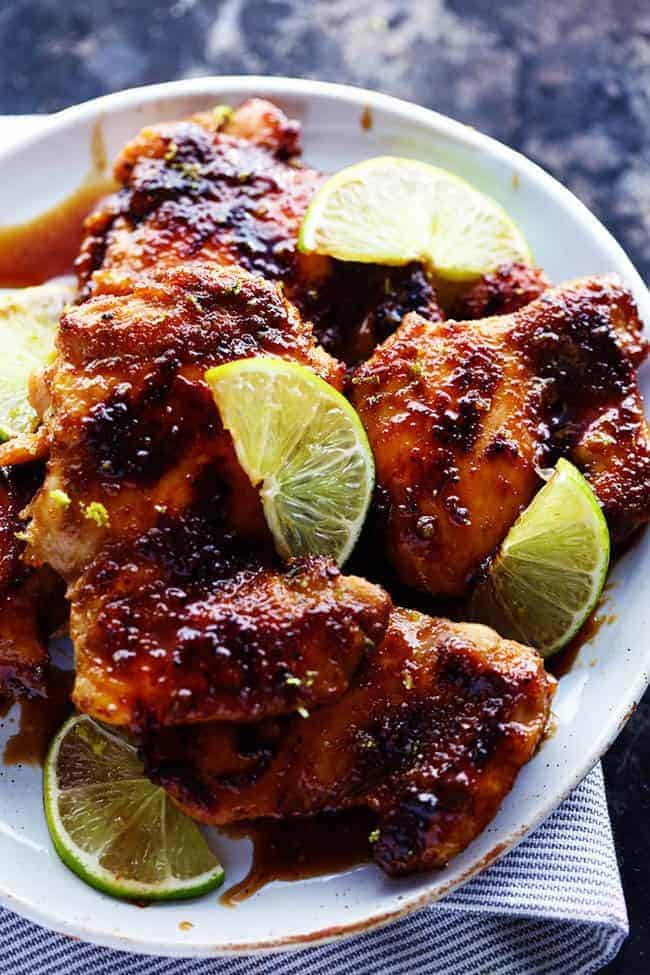 Delicious spiced rubbed chicken cooked to tender and juicy perfection. It gets glazed with the most amazing honey lime sauce and is sure to be a huge hit! Skillet honey lime chicken on a white plate.