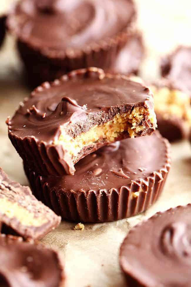Homemade Reese's Peanut Butter Cupsย come together in just 15 minutes and are even better than the real thing! Homemade Reeses peanut butter cups stacked on top of each other one with the bite taken out of it.