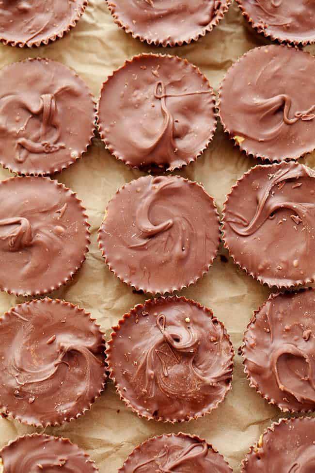 Homemade Reese's Peanut Butter Cupsย come together in just 15 minutes and are even better than the real thing! Homemade Reeses peanut butter cups on parchment paper.