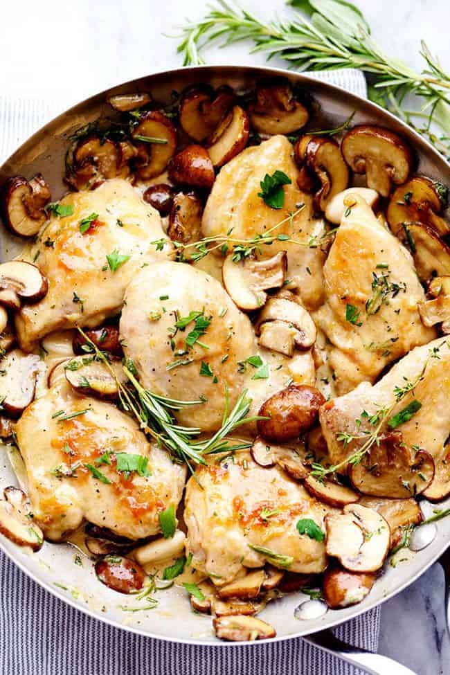 Creamy Garlic Herb Mushroom Chicken is a quick and easy 30 minute meal with amazing restaurant quality taste! The creamy garlic and fresh herb mushroom sauce over this chicken is insanely delicious! Overhead photo of Creamy Garlic Herb Mushroom Chicken in a metal frying pan.