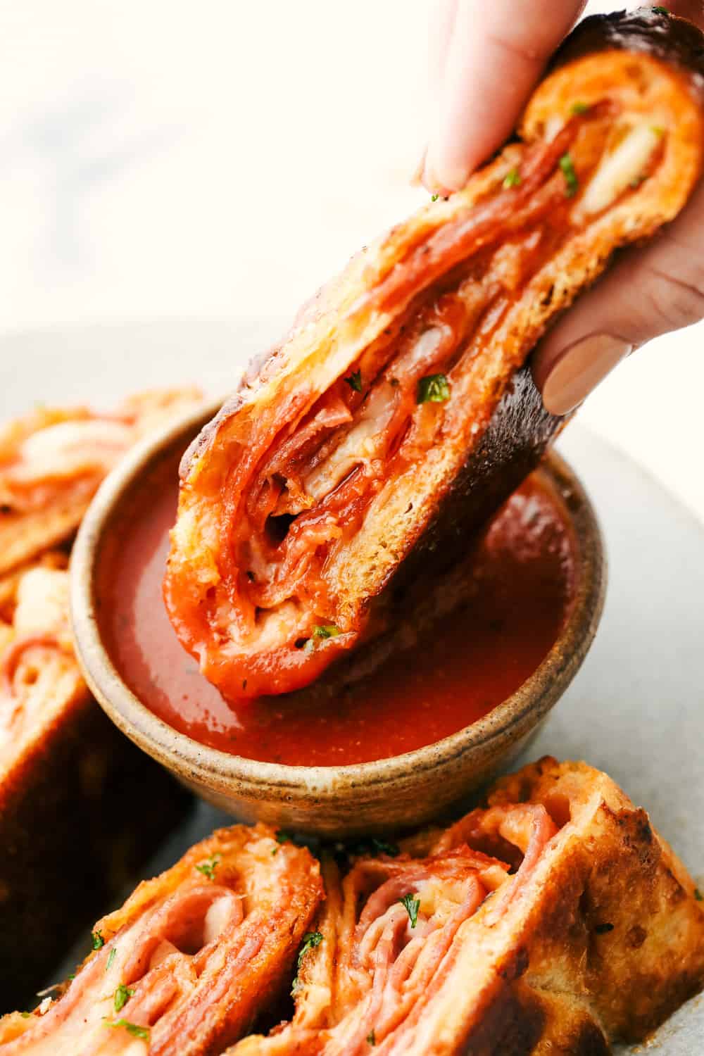 This quick and easy Stromboli gets loaded with Italian salami, pepperoni, pizza sauce and cheese. It's so quick, easy and delicious you will want to make it again and again! Stromboli slice being dipped in the marinara sauce.