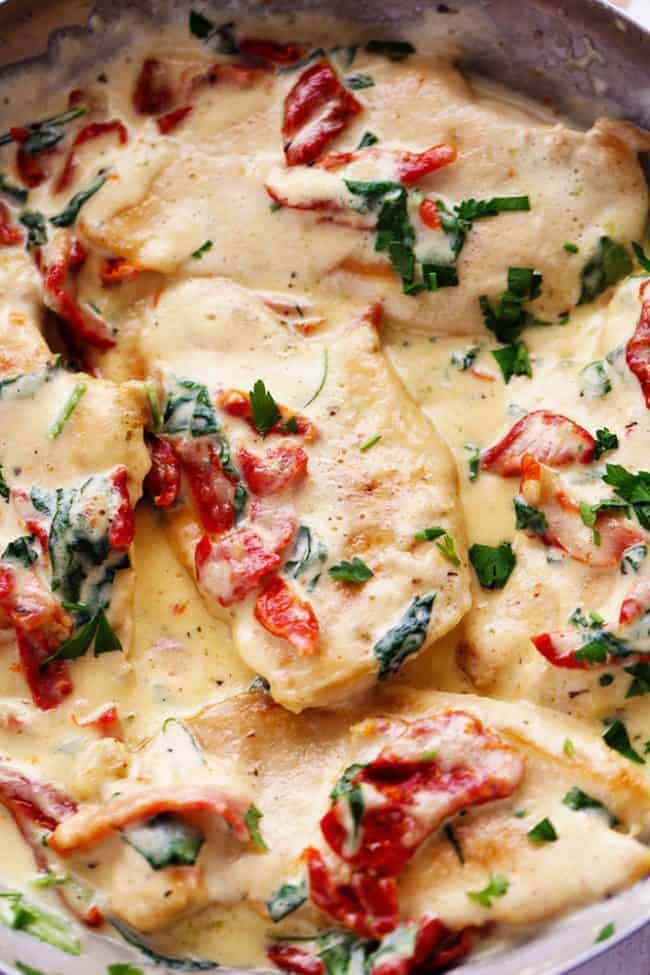 Creamy Tuscan Garlic Chicken has the most amazing creamy garlic sauce with spinach and sun dried tomatoes. This is a restaurant quality meal that's easy to make at home in just 30 minutes! Close up photo of Creamy Tuscan Garlic Chicken.