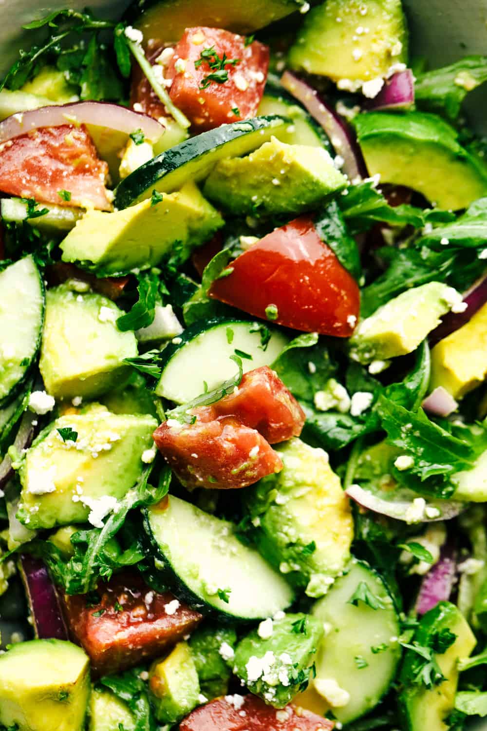 Avocado, Tomato and Cucumber Arugula Salad is fresh, delicious and light and packed with amazing flavor! ย Tossed in a tangy lemon glaze and topped with feta cheese, you won't be able to get enough!