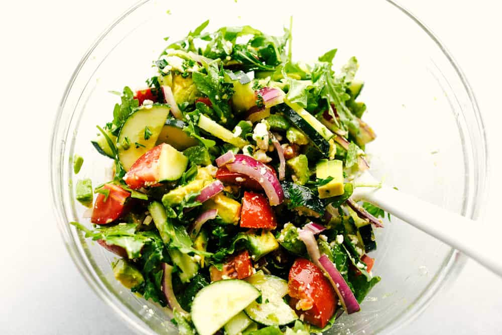 Avocado, Tomato and Cucumber Arugula Salad is fresh, delicious and light and packed with amazing flavor! ย Tossed in a tangy lemon glaze and topped with feta cheese, you won't be able to get enough! Avocado, Tomato and Cucumber Arugula Salad