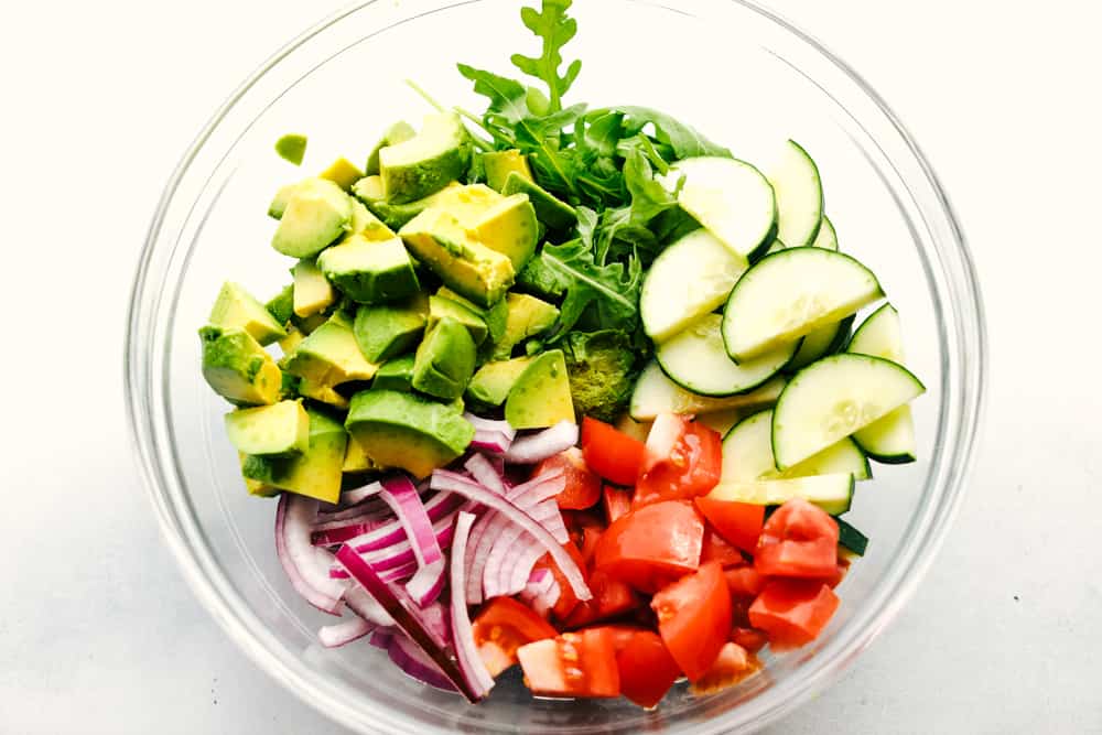 Avocado, Tomato and Cucumber Arugula Salad is fresh, delicious and light and packed with amazing flavor! ย Tossed in a tangy lemon glaze and topped with feta cheese, you won't be able to get enough! Avocado, Tomato and Cucumber Arugula Salad ingredients
