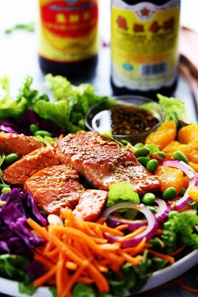 Asian Pan Seared Salmon Salad is bright and vibrant and complete with an amazing honey sesame dressing that takes this salad to a whole new level of delicious! Asian Pan Seared Salmon Salad with two bottles of soy sauce on the side.