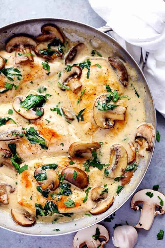 Creamy Parmesan Garlic Mushroom Chicken is ready in just 30 minutes and the parmesan garlic sauce will wow the entire family! This will become a new favorite! Overhead photo of Creamy Parmesan Garlic Mushroom Chicken in a frying pan and cut mushrooms on the side.