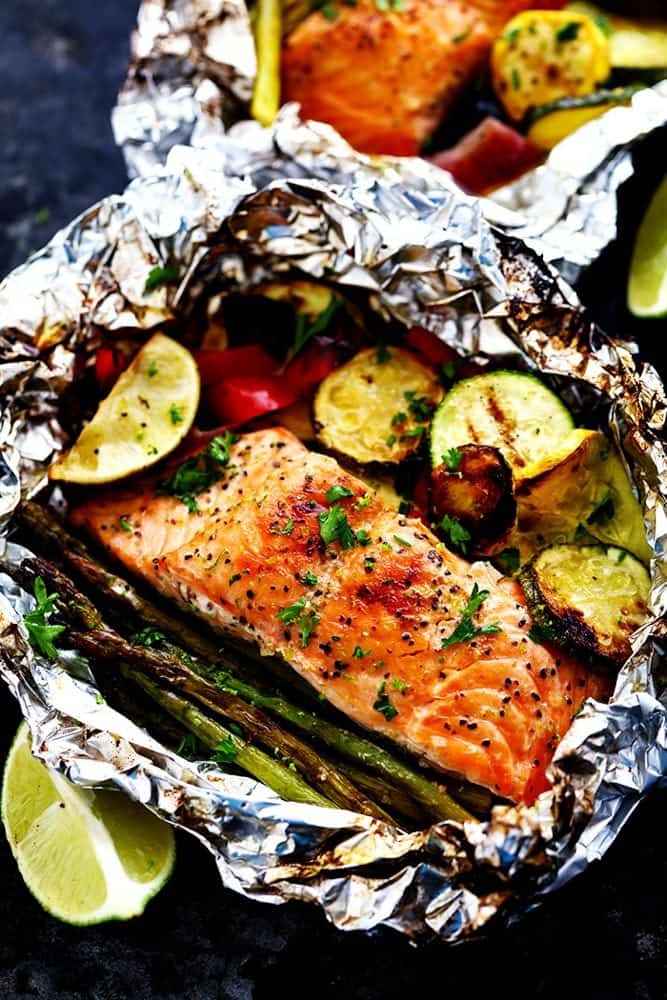 Lime Butter Salmon in Foil with Summer Veggies is grilled to tender and flaky perfection. The foil seals in the lime butter flavor and will be one of the BEST things that you eat! Lime Butter Salmon in Foil with Summer Veggies with fresh lemon on the side.