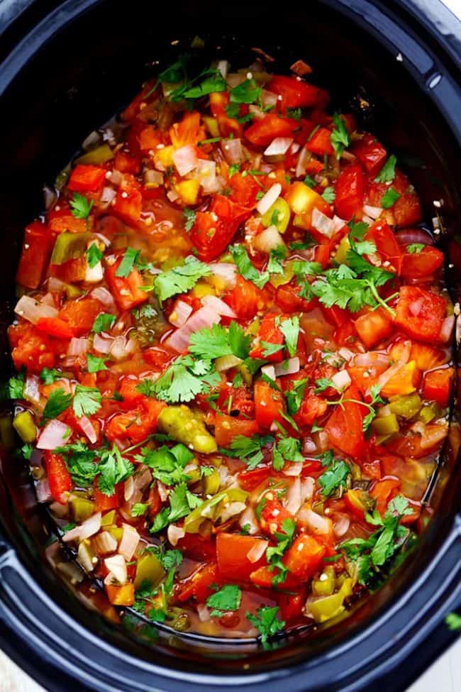 Slow Cooker Restaurant Style Garden Salsa has so many delicious and fresh ingredients and uses up all of those garden tomatoes. It is so addicting you won't be able to get enough! It is also perfect for canning. Restaurant Style Garden Salsa in a slow cooker.