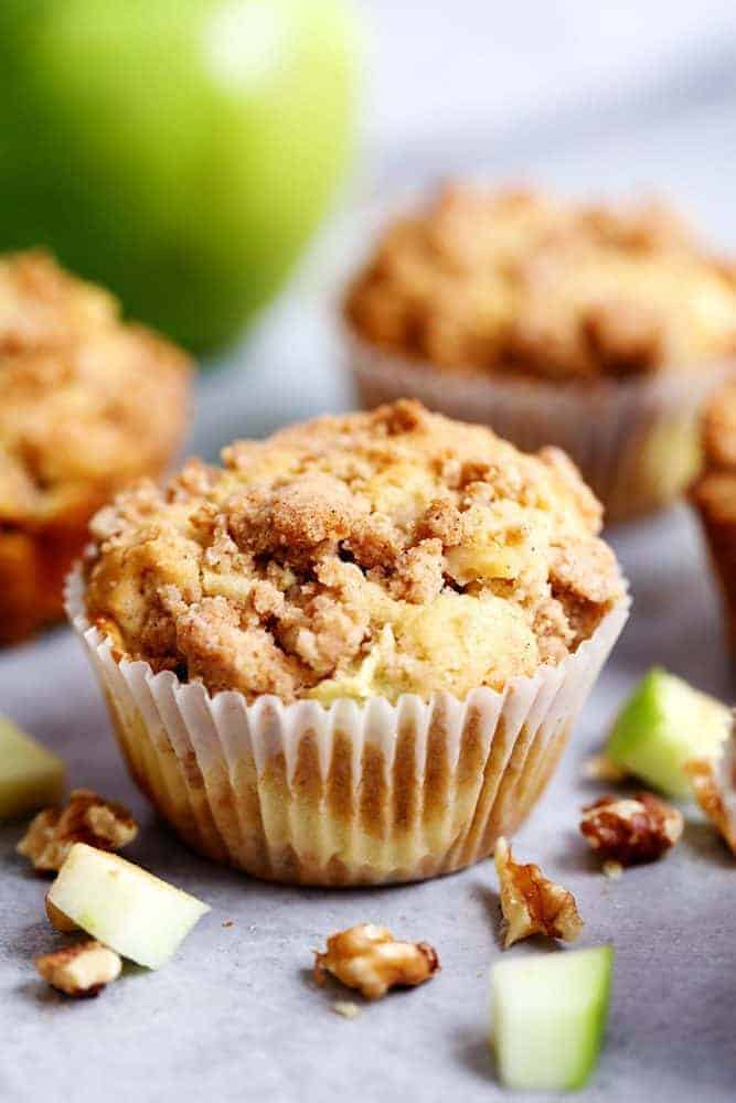 Apple Cream Cheese Crumb Muffins are the perfect buttery and moist apple walnut muffins with a hidden cream cheese center. Topped with a cinnamon sugar crumb topping these are the perfect fall muffins! Apple cream cheese come muffins