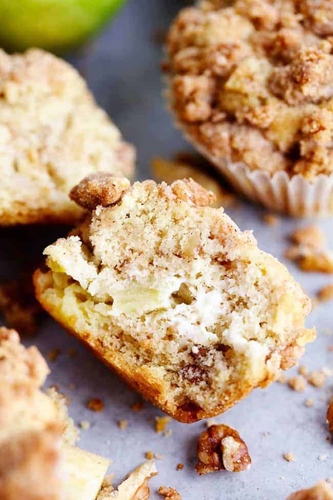 Apple Cream Cheese Crumb Muffins are the perfect buttery and moist apple walnut muffins with a hidden cream cheese center. Topped with a cinnamon sugar crumb topping these are the perfect fall muffins! Apple cream cheese crumb muffins cut in half