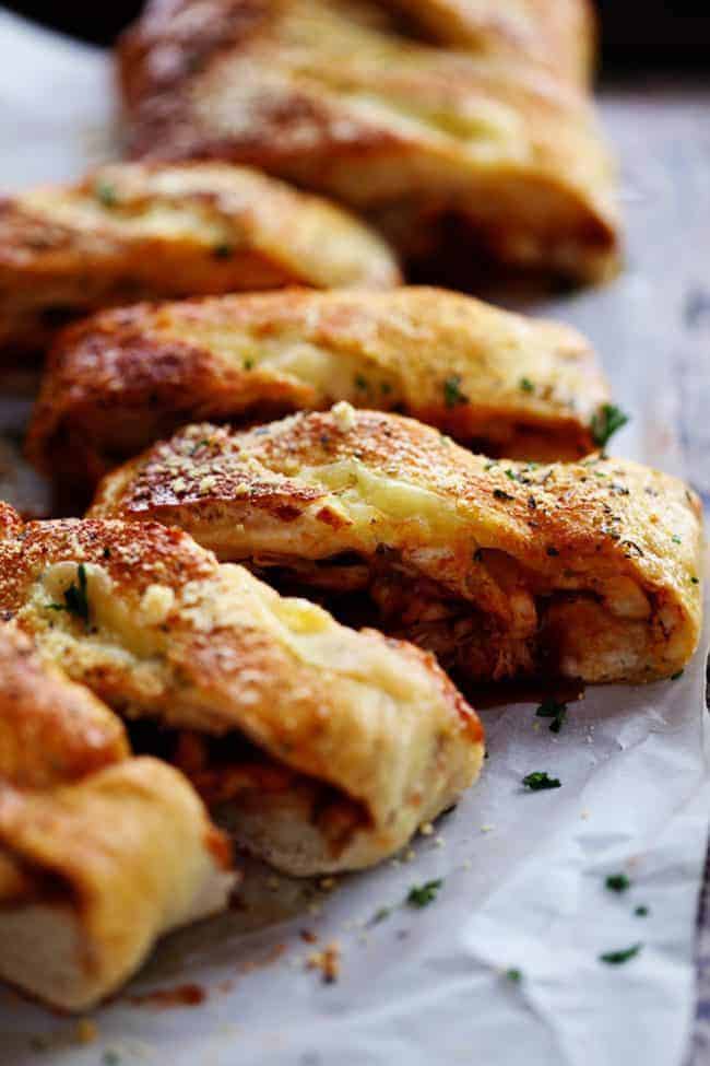 BBQ Chicken Stromboli is full of melty provolone cheese, chicken, caramelized red onions and sweet and tangy bbq sauce. This makes an amazing quick and easy meal or appetizer! BBQ chicken Stromboli cut into slices.
