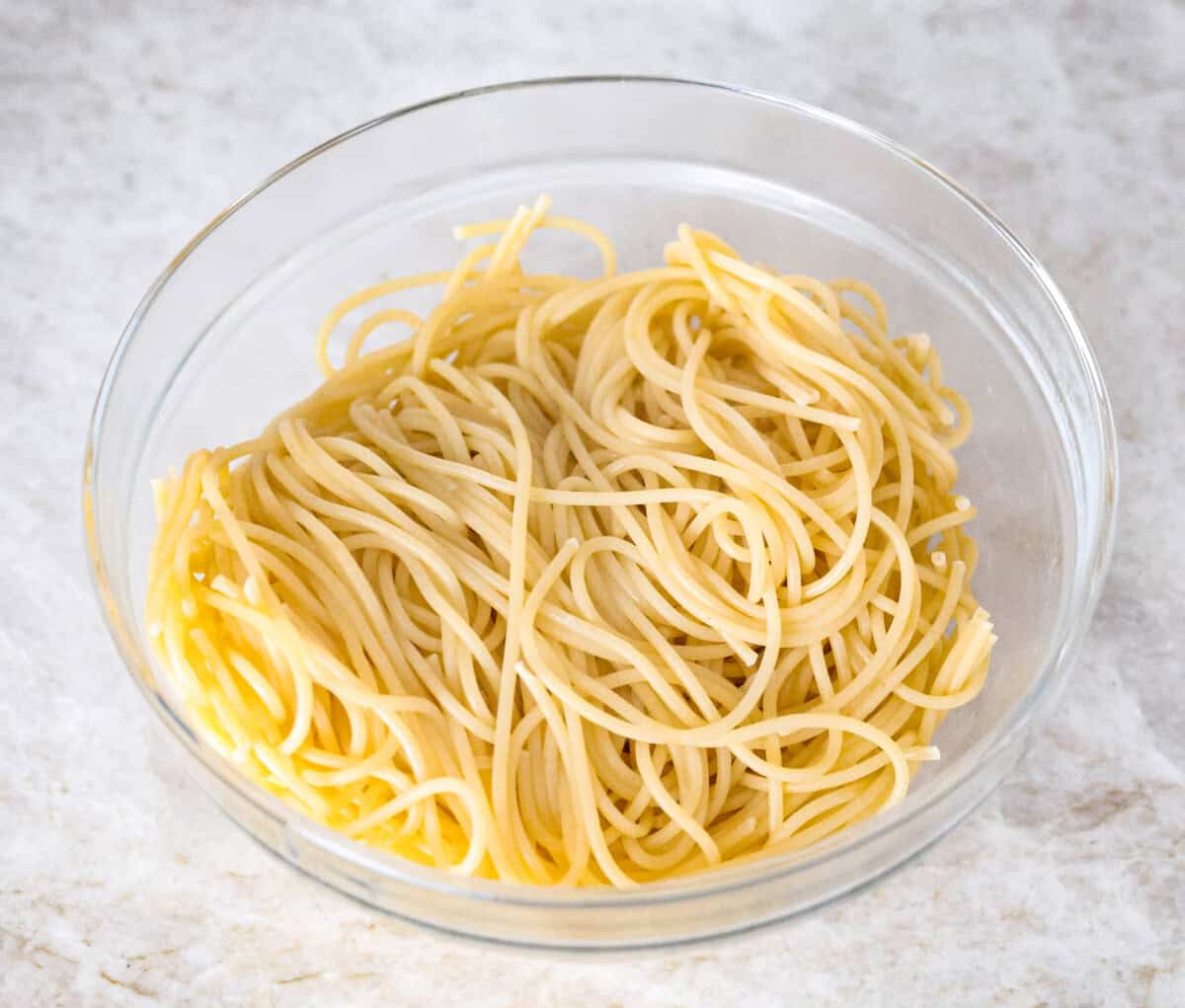 Creamy Parmesan Pasta Roni uses just 6 ingredients and one pan! It's loaded with creamy parmesan sauce and perfectly cooked al denta noodles. Your whole family will go crazy over this delicious, quick, easy meal. Overhead shot of cooked noodles in a bowl.