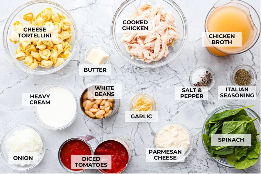 Creamy Tuscan garlic tortellini soup is so easy to make and one of the best soups that you will make! This soup is loaded with cheesy tortellini, diced tomatoes healthy spinach and hearty white beans. This soup is so creamy and delicious, I know your family will love it! Overhead shot of labeled ingredients.