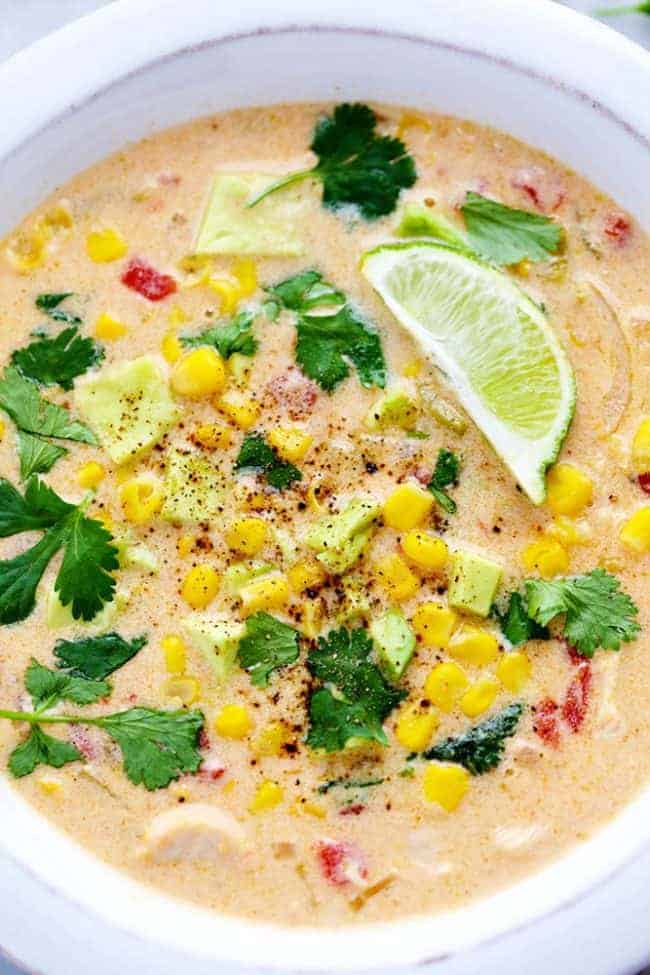 Mexican Chicken Corn Chowder is creamy, cheesy and so easy to make! ย It has just enough of a kick to it and the flavor is incredible. ย This will be one of the best chowders that you will eat! Mexican chicken corn chowder in a bowl with toppings on it.