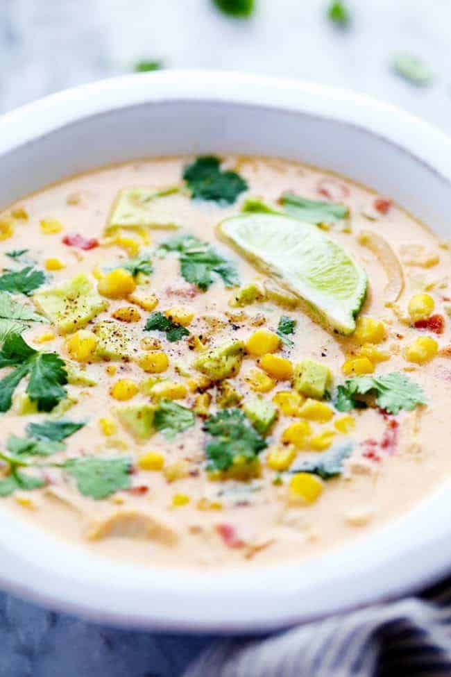 Mexican Chicken Corn Chowder is creamy, cheesy and so easy to make! ย It has just enough of a kick to it and the flavor is incredible. ย This will be one of the best chowders that you will eat! Mexican chicken corn chowder in a bowl with toppings on it.