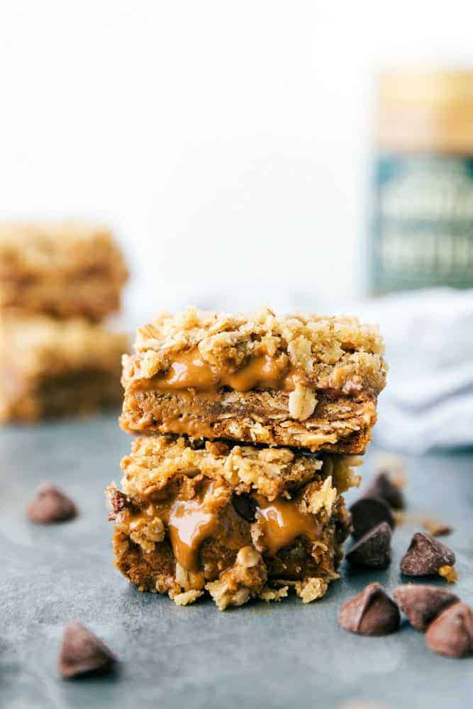 Biscoff Oatmeal Bars are easy to make oatmeal bars with a thick layer of biscoff and milk chocolate! Biscoff Oatmeal bars stacked on top of each other with chocolate chips on the side.