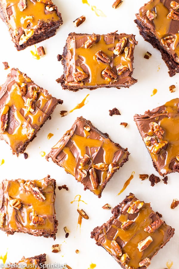 Frosted Turtle Brownies sliced on a white background. 