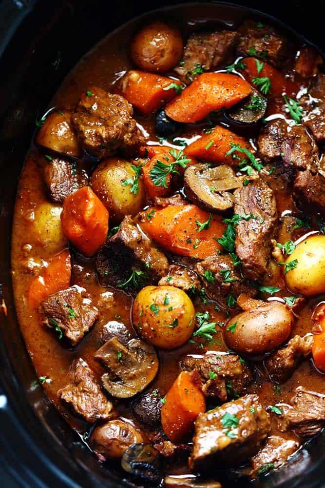 Slow Cooker Beef Bourguignon has crazy tender melt in your mouth beef and hearty veggies slow cooked to perfection in a rich sauce. ย This meal is comforting and perfect for the cold months ahead! Slow Cooker Beef Bourguignon