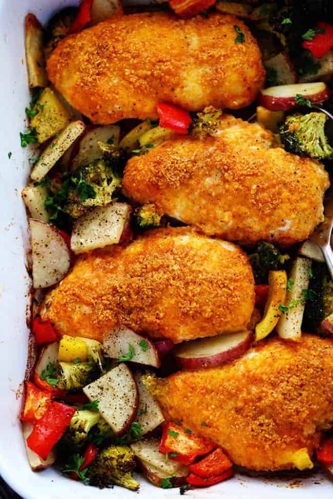One Pan Crispy Parmesan Paprika Chicken with Vegetables has tender and juicy chicken with a crispy parmesan paprika breading surrounded by veggies. It it is full of flavor and makes an amazing one pan dinner your family will love! Crispy Parmesan paprika chicken with vegetables and a casserole dish.