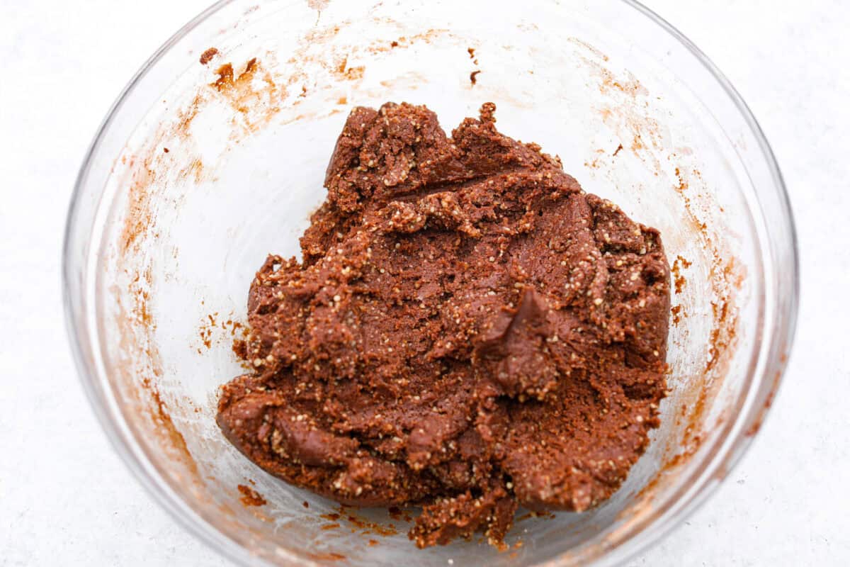 Chocolate Snowball Cookies are tender chocolate cookies with the best texture! A buttery cookie made with cocoa powder and ground walnuts gets coated in sweet powdered sugar. Make this classic holiday cookie a tradition every year! Fifth photo of the dough mixed together and the nuts stirred in.