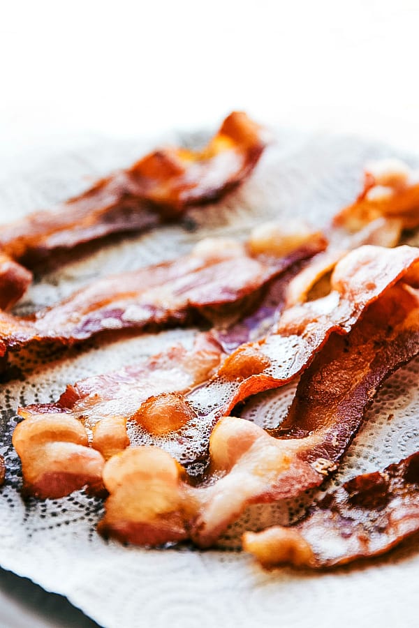 Skillet Maple Bacon Cinnamon Roll is an easy to make cinnamon roll skillet cake with maple cream cheese frosting and crumbled bacon. The perfect holiday breakfast! Sliced bacon on a paper towel.