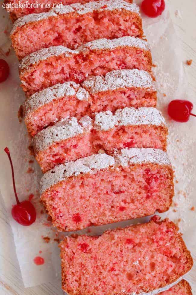 Cherry Almond Bread is so quick and easy to make and perfectly moist! The cherry almond flavor is incredible and you won't be able to get enough!ย Cherry Almond Bread sliced into pieces with cherries on the side.