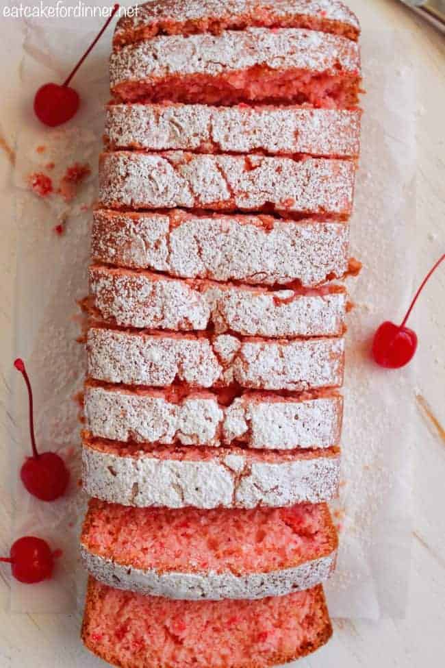 Cherry Almond Bread is so quick and easy to make and perfectly moist! The cherry almond flavor is incredible and you won't be able to get enough!ย Overhead shot of cherry almond bread sliced into pieces with cherries on the side.