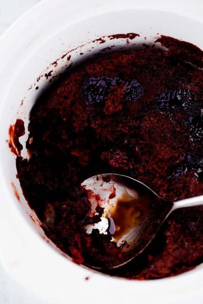 Slow Cooker Cherry Chocolate Hot Fudge Cake is a perfectly tender chocolate cake with hidden cherries inside. It creates a magical fudge sauce while it is in the slow cooker and is completely irresistible! Cherry chocolate hot fudge cake in the slow cooker with a silver spoon dishing it out.