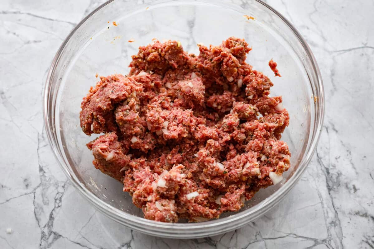 Mozzarella Stuffed Meatballs take classic meatballs to the next level! Tender and juicy with melty cheese on the inside. Serve these meatballs as a party appetizer or over spaghetti noodles for a hearty meal! Second photo of the meatball mixture mixed in a bowl.