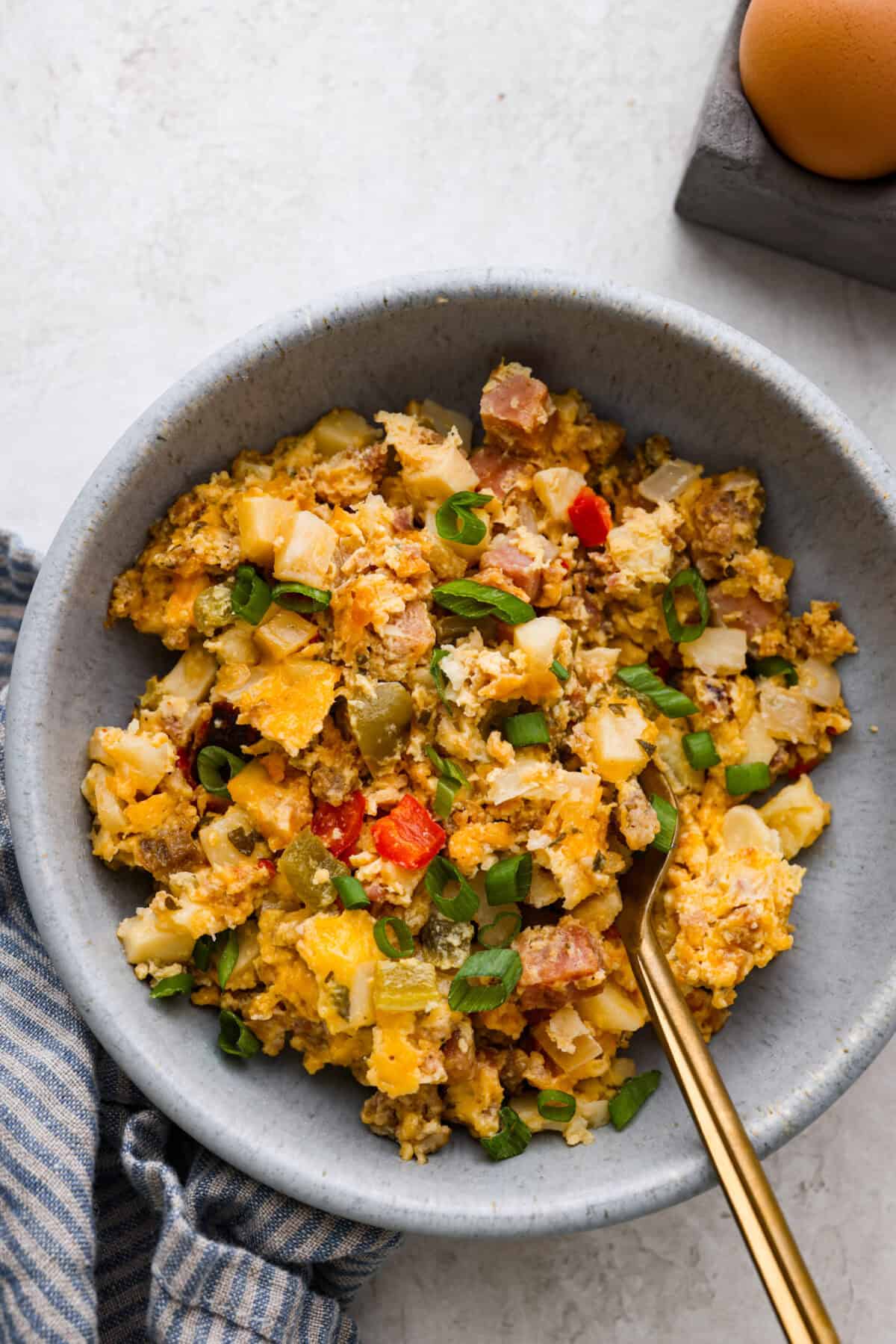 This Slow Cooker Breakfast Casserole is quick and easy to put together! Breakfast can be cooked in the slow cooker while you're sleeping! This casserole is loaded up with seasoned sausage, diced hash browns, tender vegetables, eggs, and cheese. Overhead shot of plated slow cooker breakfast casserole.