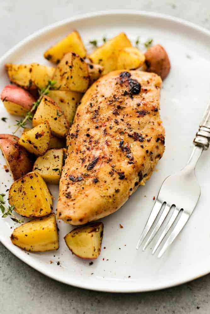 Slow Cooker Italian Chicken and Potatoes is such an easy meal to make but packed with such amazing flavor! The entire family will love this hearty meal in one. Slow cooker Italian chicken and potatoes on a white plate with a fork on the side.