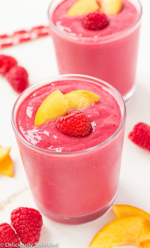 Raspberry Peach Smoothie- a delicious and simple smoothie filled with raspberries, peaches and vanilla greek yogurt. Raspberry Peach Smoothie in a glass.