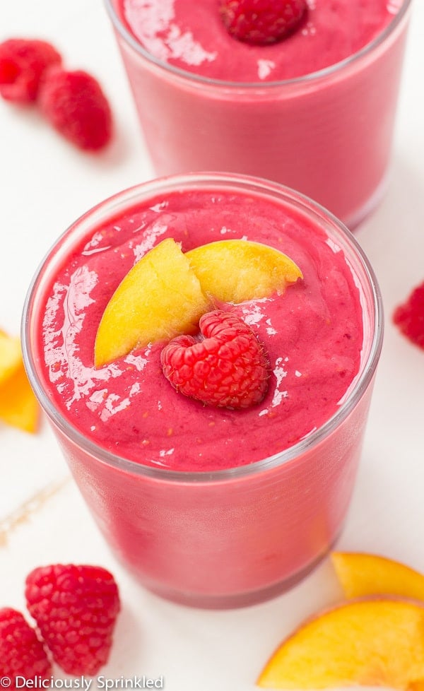Raspberry Peach Smoothie- a delicious and simple smoothie filled with raspberries, peaches and vanilla greek yogurt. Raspberry Peach Smoothie in a glass cup.