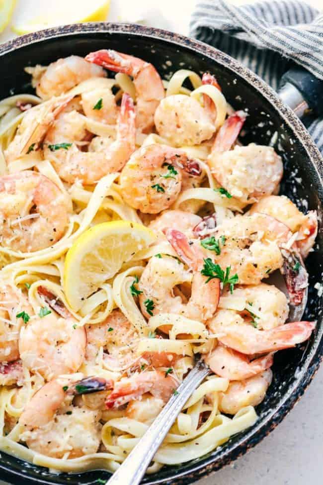 Creamy Parmesan Garlic Shrimp Pasta is the perfect quick and easy meal that is on the dinner table in less than 20 minutes! Shrimp get coated in the very best creamy parmesan garlic sauce and is wonderful tossed with fresh pasta. Creamy Parmesan Garlic Shrimp Pasta in a saute pan.