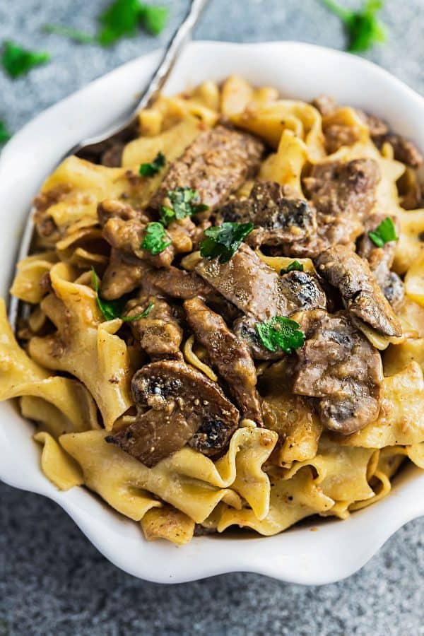 One Pot Beef Stroganoff has all the delicious flavors you love about this classic comfort food made easier in just ONE pan! Strips of tender beef, soft egg noodles coated in a creamy mushroom sauce and perfect for busy weeknights! one pot beef stroganoff in a bowl.