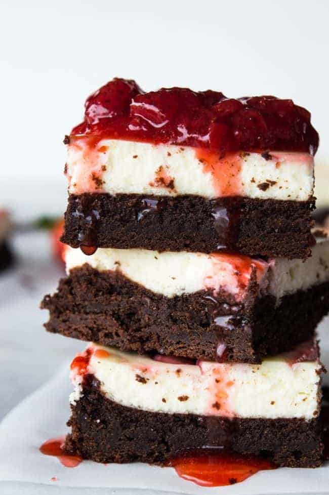 Strawberry Cheesecake Brownies. These homemade brownies are loaded up with a layer of creamy cheesecake then swirled with a sweet strawberry sauce for a pop of color and flavor! Spoon the extra strawberry sauce over the top for an extra special dessert!ย Stack of Strawberry Cheesecake Brownies.