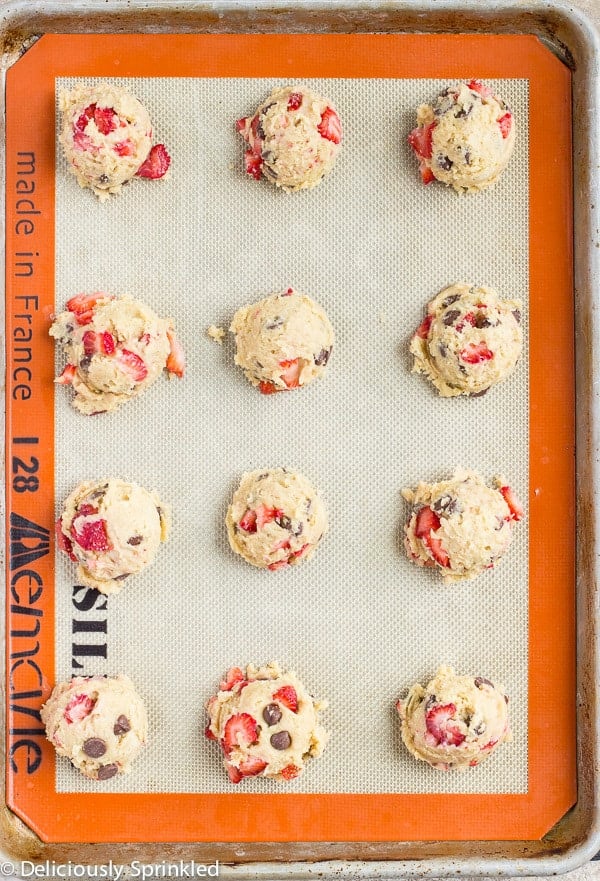 Strawberry Chocolate Chip Cookies- These homemade Strawberry Chocolate Chip cookies are loaded with fresh strawberries and milk chocolate chips. Strawberry Chocolate Chip Cookie dough in rows on a tray.