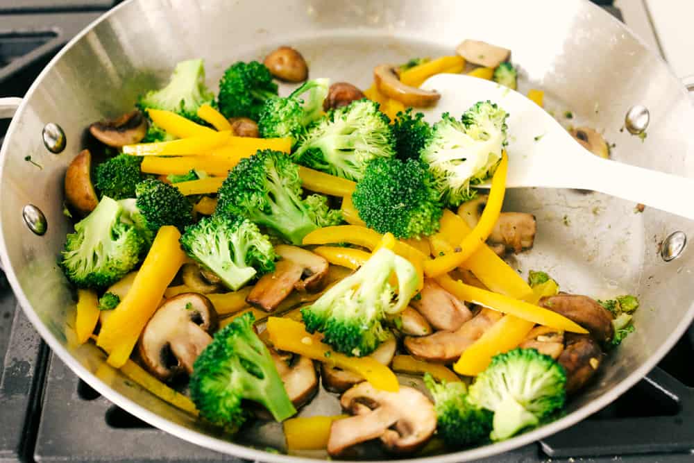 This garlic chicken stir fry is a quick and easy dinner that's perfect for those busy weeknights. Cubes of chicken are cooked with colorful veggies and tossed in a flavorful garlic sauce for a meal that's way better than take out! Sauteing mushrooms, peppers, and broccoli.